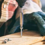 Carpenter working with an electric screwdriver on the work bench