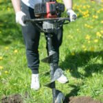 Ploughing land with drill. Digging tool. Landscaping of park. Gardener’s job.